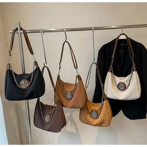 Detail view of five vintage suede crescent bags in assorted colors with M logo ornaments