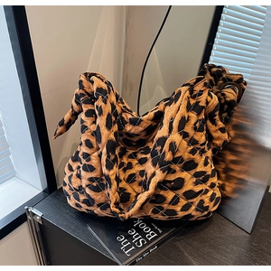 Détail du sac fourre-tout matelassé à motif léopard avec tissu rembourré et poignée nouée