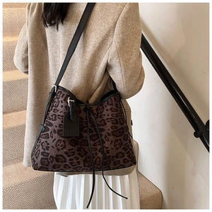 Detail of leopard print tote bag featuring black leather straps and fashion leather tag