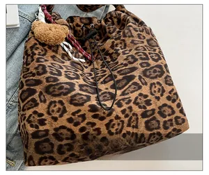Detailed view of leopard print bucket bag with drawstring closure and plush bear charm