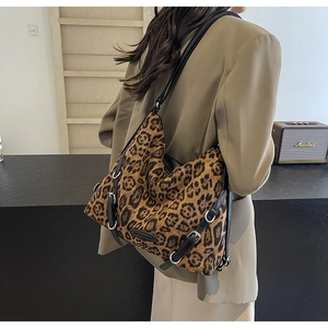 Vista dettagliata della borsa tote leopardata indossata a spalla da una modella