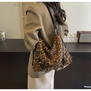 Dettaglio borsa tote leopardata con spalline in pelle nera e fibbie in metallo