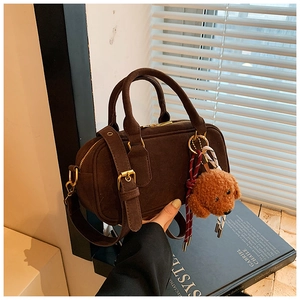 Dettaglio della borsa Boston in camoscio marrone con cerniera dorata e ciondolo a cane