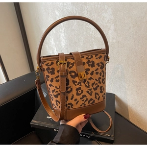 Detail der Leoparden-Beuteltasche mit braunem Lederriemen und goldener Metallschnalle