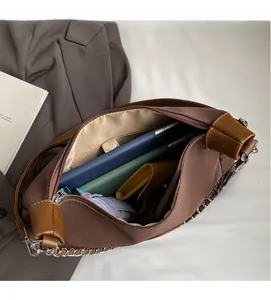 Spacious interior of a dark brown chain tote bag with daily essentials inside