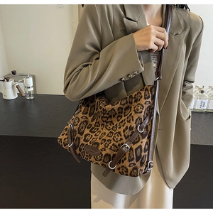 Dettaglio della borsa a tracolla leopardata con cinturino in pelle marrone e logo patch