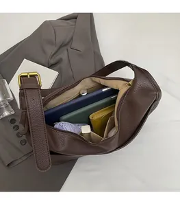 Spacious interior of brown lychee pattern crescent bag with essentials like a phone and wallet