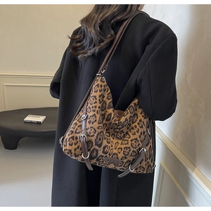 Dettaglio della borsa tote leopardata con cinturini in pelle marrone e fibbia d'argento