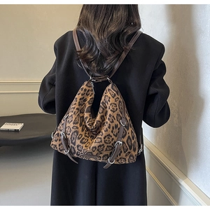Dettaglio della borsa a tracolla leopardata con texture morbida e manici marroni