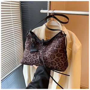Detail shot of leopard print tote bag with black leather strap and Fashion tag