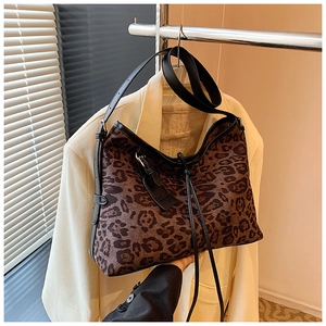 Close-up of leopard print tote bag with black leather strap and Fashion brand tag