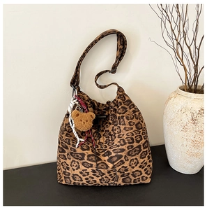 Detail of leopard print bucket bag with drawstring closure and brown bear charm