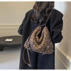 Dettaglio macro della borsa hobo leopardata con fibbie in pelle per tracolla regolabile