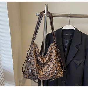 Dettaglio della borsa hobo leopardata con cinturini in pelle marrone e fibbie d'argento