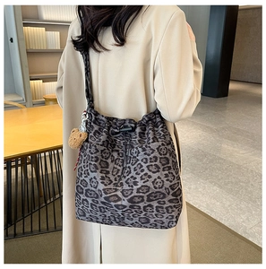 Leopard print bucket bag with drawstring and cute bear charm shown on a model's shoulder