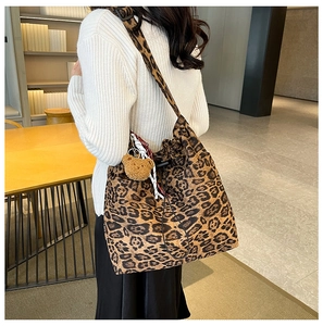 Leopard print tote bag with drawstring closure and brown plush bear charm detail