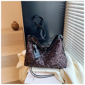Detail of leopard print tote bag featuring black leather trim and fashion tag