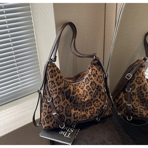 Dettaglio della borsa tote leopardata con tracolla in pelle marrone e fibbie argento