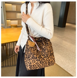 Detail of leopard print bucket bag with drawstring closure and mini bear charm accessory