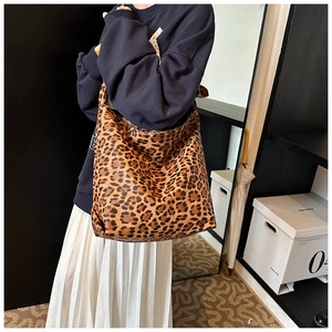 Leopard print canvas hobo bag worn by model in a minimalist stylish indoor setting