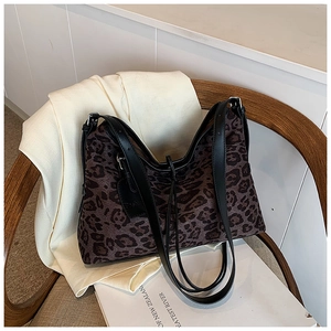 Leopard print tote bag detail on a wooden chair showing fabric texture and strap