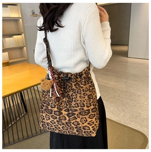 Leopard print bucket bag detail showing drawstring closure and cute brown bear pendant