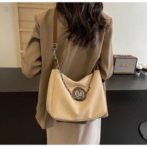 Detail of beige hobo bag with vintage metal M logo and Marshall speaker background