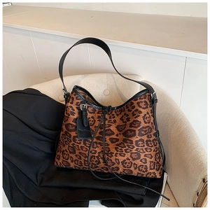 Detail of leopard print tote bag with black leather straps and Fashion embossed tag