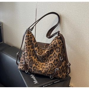 Dettaglio borsa a tracolla leopardata con cinturino in pelle marrone e anelli d'argento