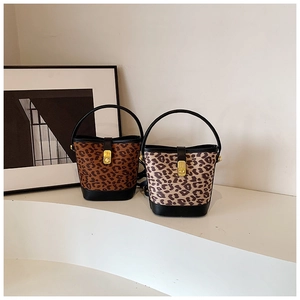 Close-up of leopard print bucket bags with gold twist locks and black leather details