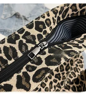 Détail de la fermeture éclair argentée fluide sur un sac en toile à imprimé léopard