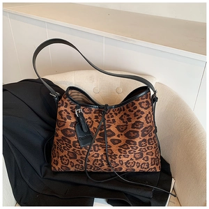 Detail of leopard print tote bag with black fashion tag on a stylish leather chair