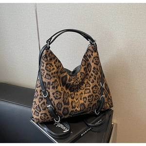 Dettaglio della borsa tote leopardata con finiture argentate e tracolle in pelle nera