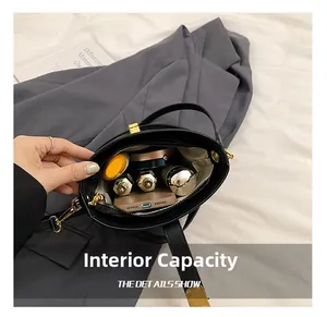 Internal storage detail of black leather bucket bag with phone and cosmetics