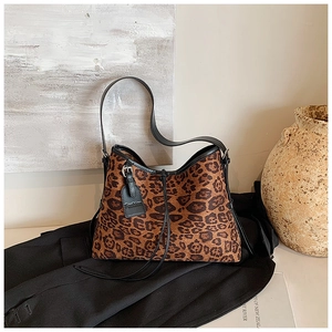 Detailed close-up of leopard print tote bag texture with black fashion brand tag