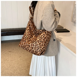 Side view of a vintage leopard print bucket bag on a model for daily commuting style