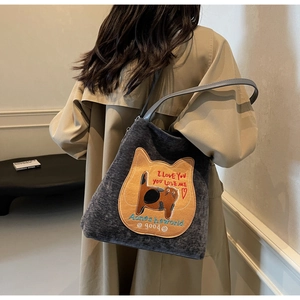 Dettaglio della borsa tote in velluto grigio scuro con ricamo gatto giallo e manici PU