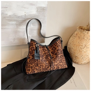 Detail view of leopard print tote bag with black leather trim and fashion tag