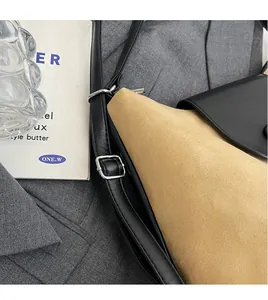 Detail of adjustable leather strap and metal buckle on a two-tone minimalist tote bag