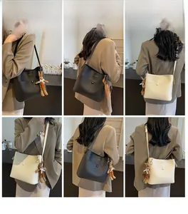 Lifestyle shots showing black and beige leather bucket bags with bunny charms in a cafe