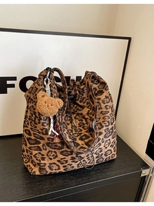 Leopard print drawstring tote bag with plush bear charm and black shoulder strap