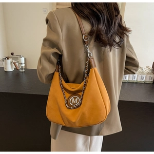 Detail of hobo bag featuring chain strap, adjustable buckle and M logo emblem