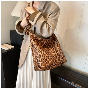 Lifestyle shot of large leopard print bucket bag styled with a professional suit