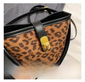 Close-up of leopard print bucket bag featuring a premium gold metal twist lock buckle