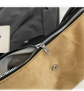 Macro view of smooth metal zipper and herringbone fabric lining on a yellow suede tote bag
