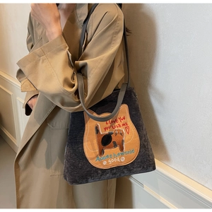 Dettaglio della borsa tote in velluto a coste grigio con patch gatto e stile casual