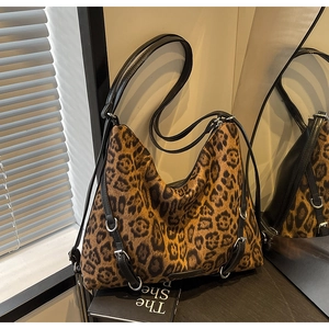 Dettaglio borsa leopardata con spalline in pelle nera e fibbie metalliche argentate lucide
