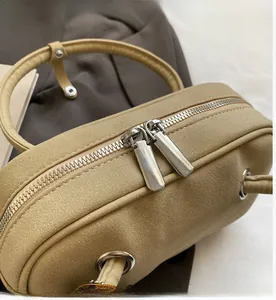 Détail de la double fermeture éclair argentée et de la texture mate du sac vintage