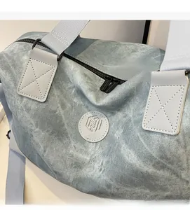 Detailed view of NINGJIA blue travel bag showing textured fabric and brand logo patch