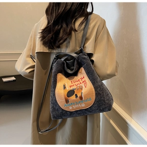Dettaglio borsa tote in velluto a coste grigio scuro con ricamo gatto arancione e tracolla